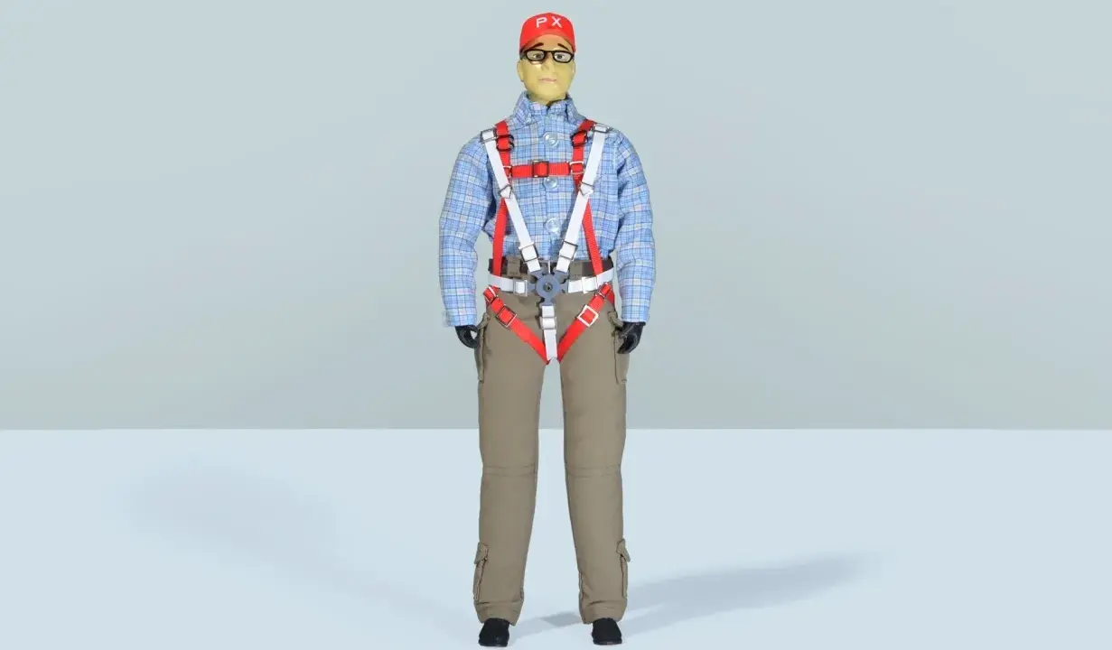 Eine detailreiche **Pilotenpuppe** mit kariertem Hemd, beige Hose und auffälligem roten Gurtzeug.