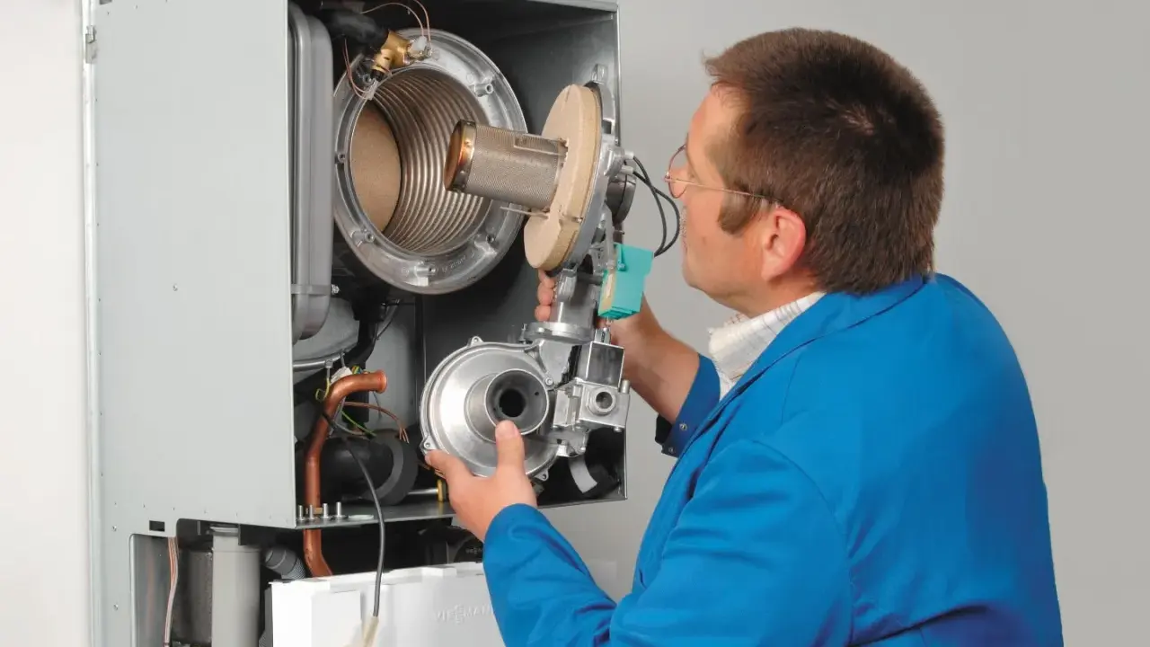 Serwisant sprawdza ciśnienie wody w kotle Viessmann Vitodens 050.