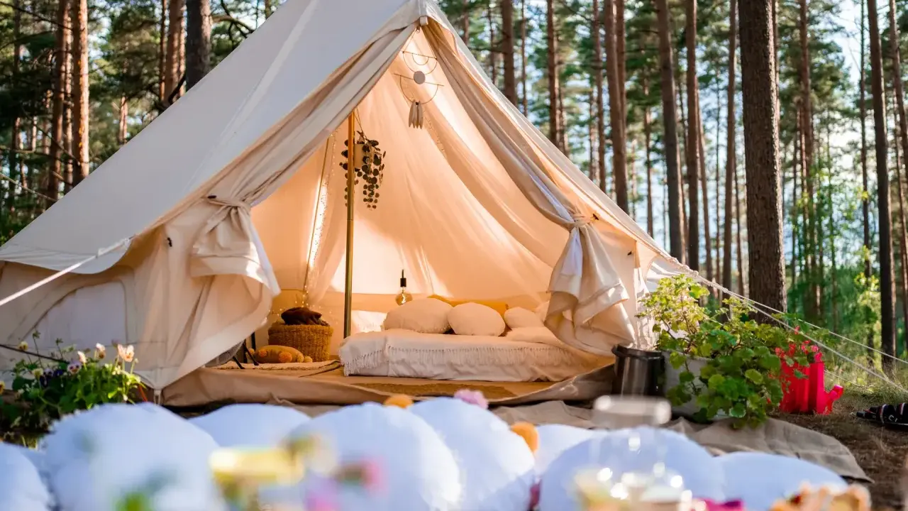 Przytulny namiot w lesie, idealny na glamping w Polsce. Wygodne łóżko, dekoracje i otoczenie natury tworzą magiczną atmosferę.