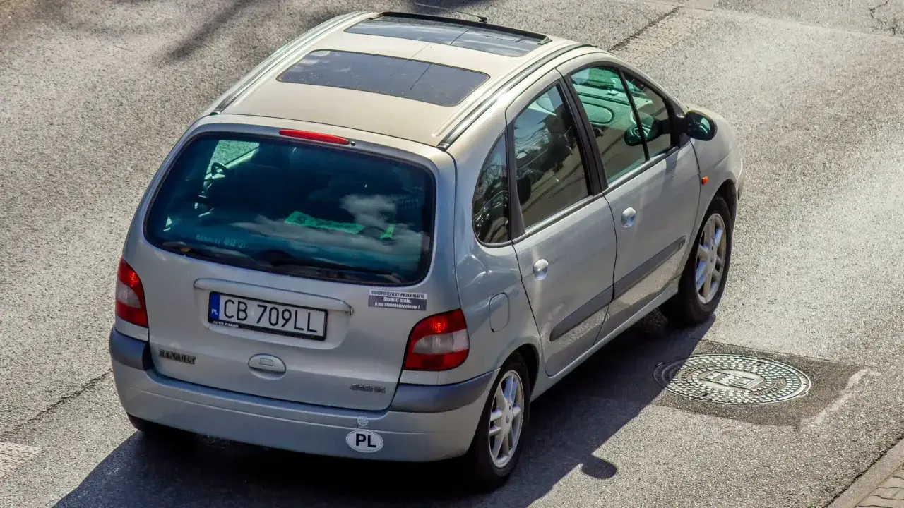 Srebrny Renault Scenic z naklejką "Ubezpieczony przez mafię". Szybkie auta i zimna noc, jak w tekstach SB MAFFIJA.