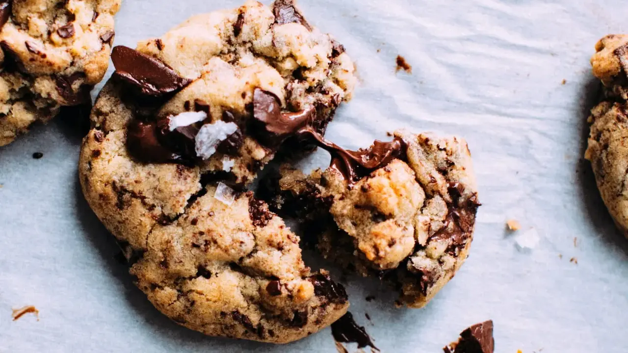 Des cookies aux pépites de chocolat fondantes, parfaits pour apprendre comment faire des cookies maison. Le chocolat coule, invitant à la dégustation.