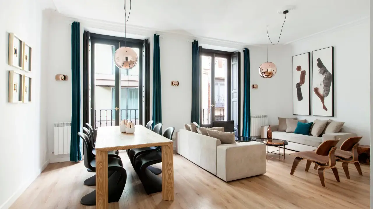 Amplio salón comedor rectangular de 25 metros con sofás, mesa de madera y sillas modernas.
