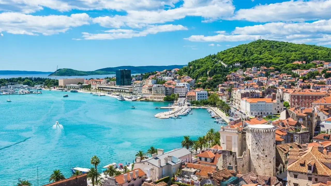 Widok na Split, Chorwacja. Błękitne morze, białe łodzie i zielone wzgórze tworzą malowniczy krajobraz. Ciekawe miejsca czekają!