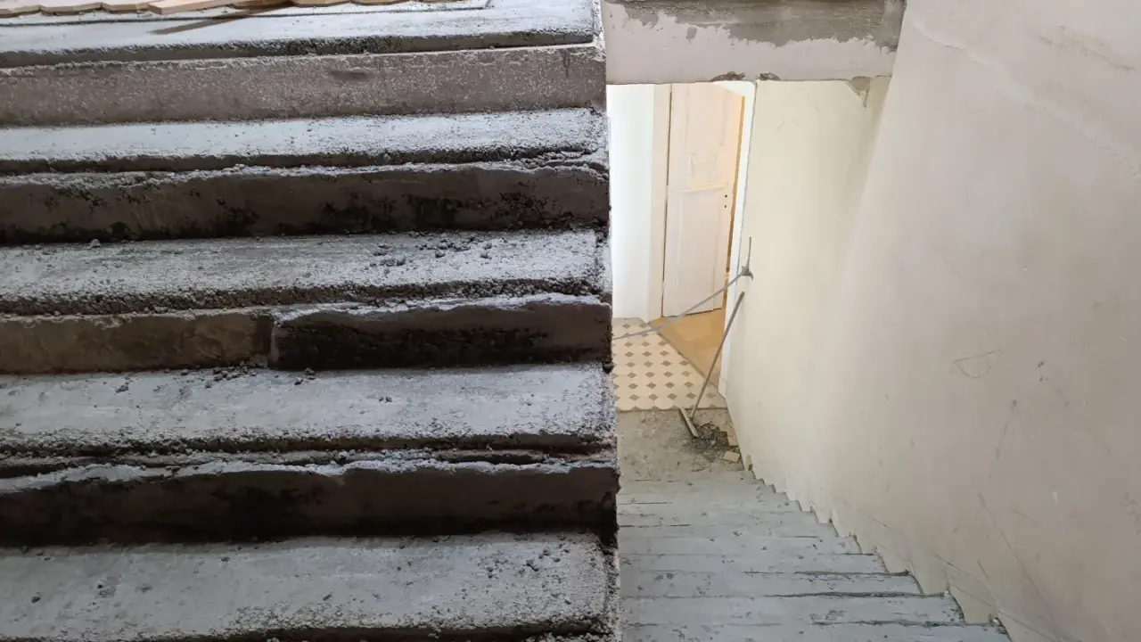 Surowe schody betonowe czekają na malowanie lastryko. Trwa remont klatki schodowej.