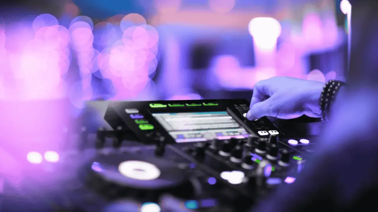 Mano su mixer, luci viola e rosa sfocate, creando l'atmosfera perfetta per la musica tech house.