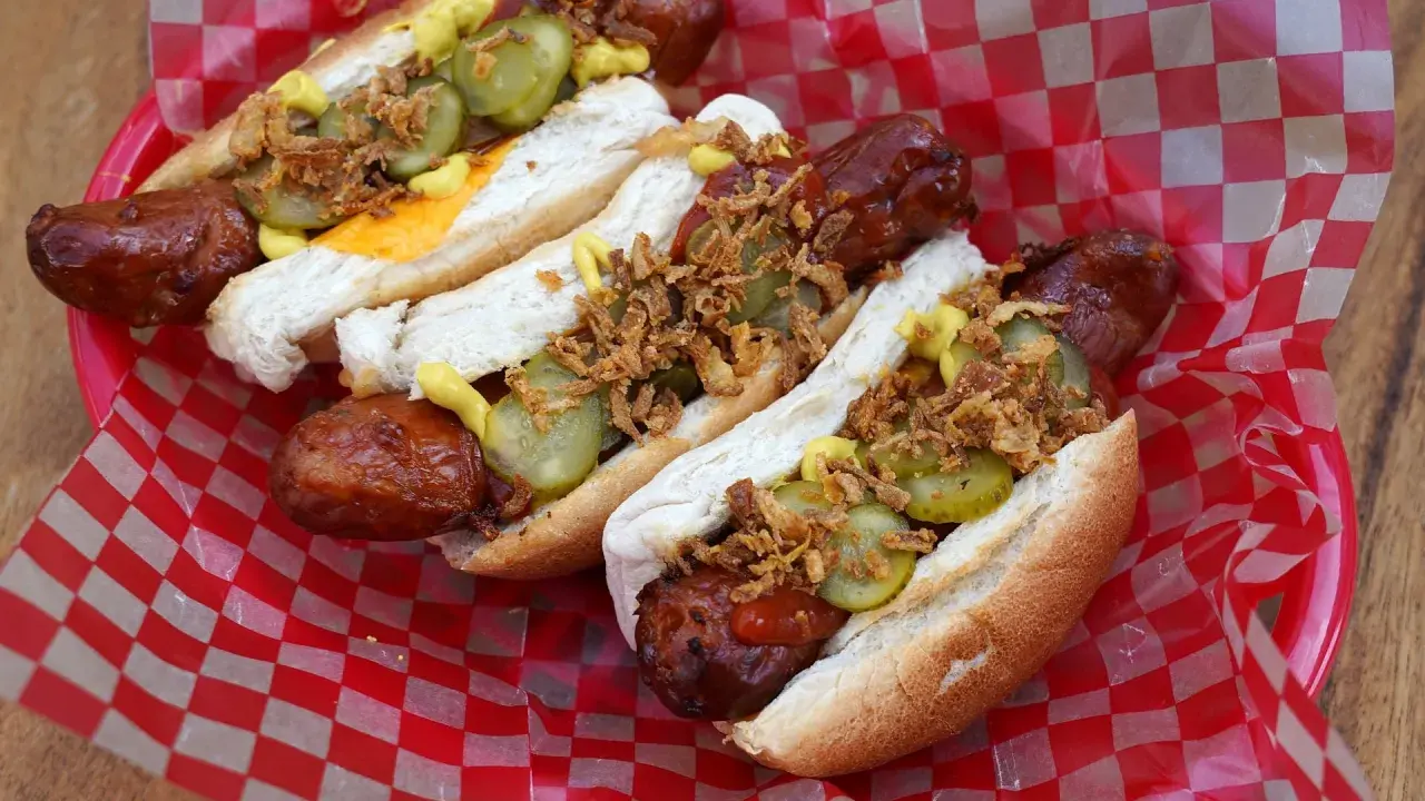 Heißer Hot Dog aus dem Airfryer, belegt mit Gurken, Zwiebeln und Senf. Perfekt für einen schnellen Snack!
