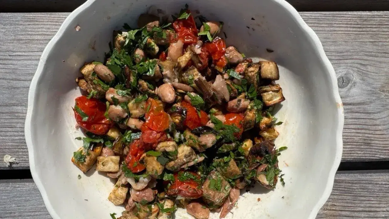 Bunter Gemüsesalat mit Auberginen, Tomaten und Bohnen, garniert mit Petersilie. Ein gesundes Gericht, inspiriert von TCM-Rezepten.