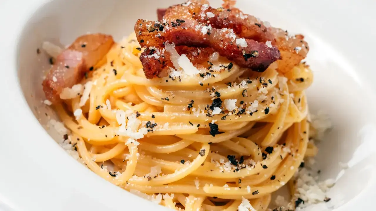 Pyszna carbonara z chrupiącym boczkiem, posypana parmezanem i pieprzem. Idealny boczek do carbonary to klucz do sukcesu.