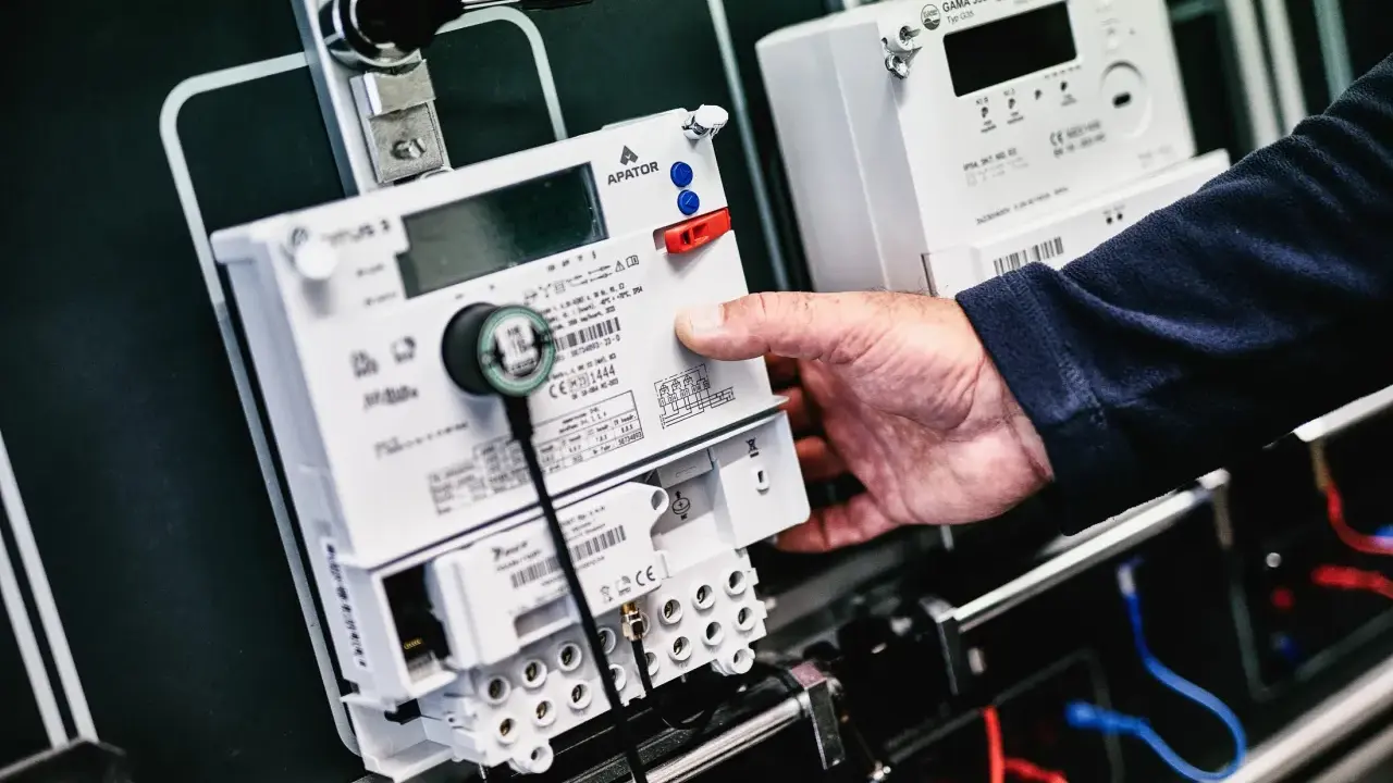 Dłoń manipuluje przy liczniku zdalnego odczytu PGE. Nowoczesne urządzenia do monitorowania zużycia energii.