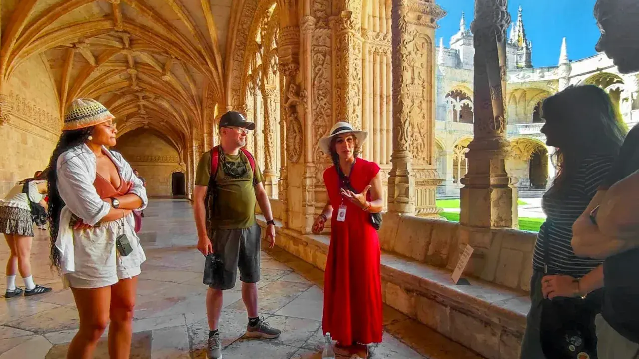 Besucher lauschen einer Führerin im Jeronimos Kloster. Die Architektur ist detailreich und beeindruckend.