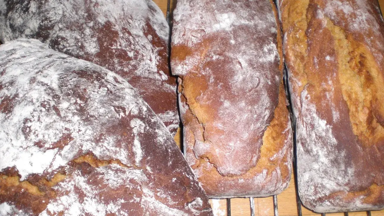 Nybakade sirapslimpor, pudrade med mjöl, redo att avnjutas. Ett perfekt sirapslimpa recept för hembakat bröd.