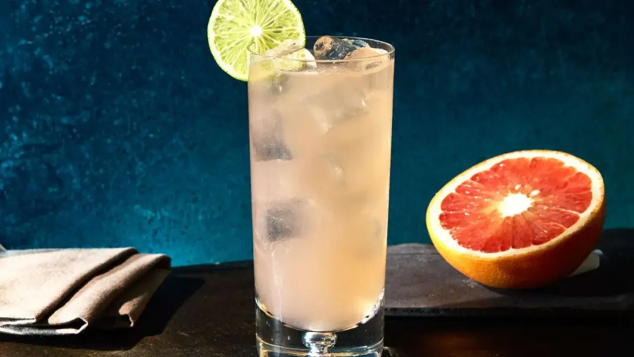 Erfrischender Greyhound Cocktail mit Eis, Limettenspalte und Grapefruit-Hälfte.
