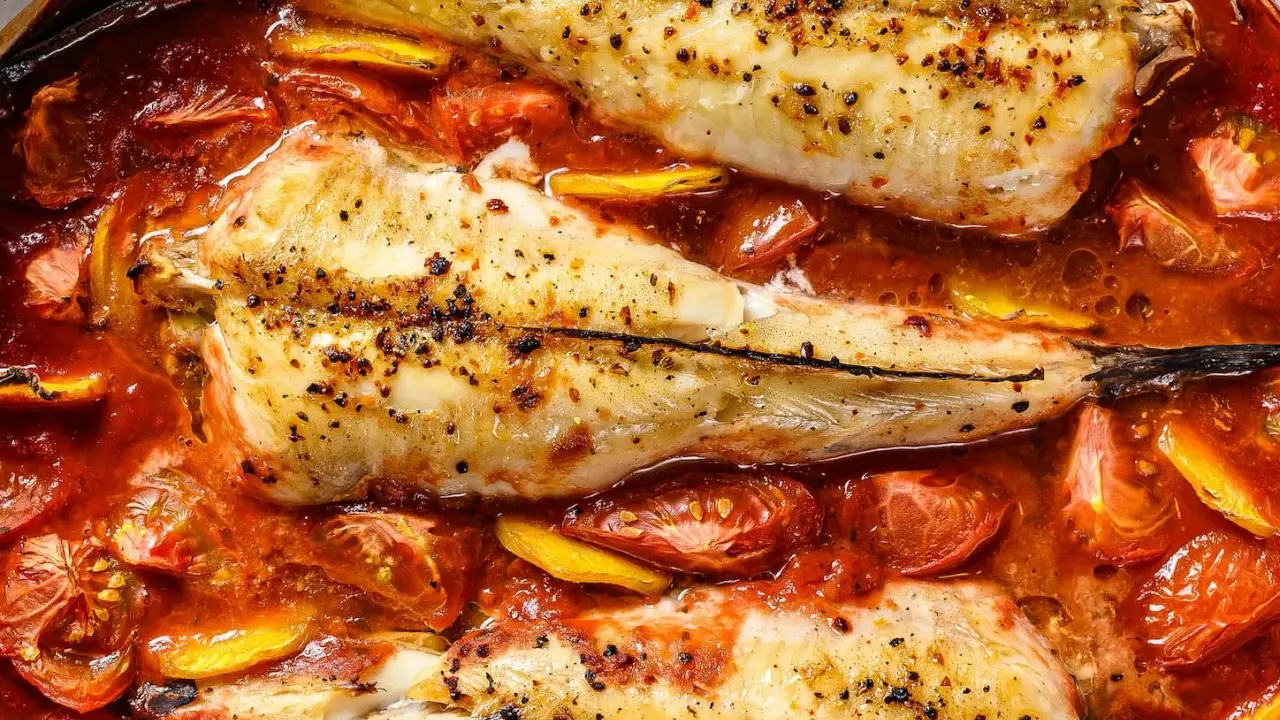 Colas de rape al horno, tiernas y jugosas, nadando en una salsa de tomate y limón. Un plato delicioso y fácil de preparar.