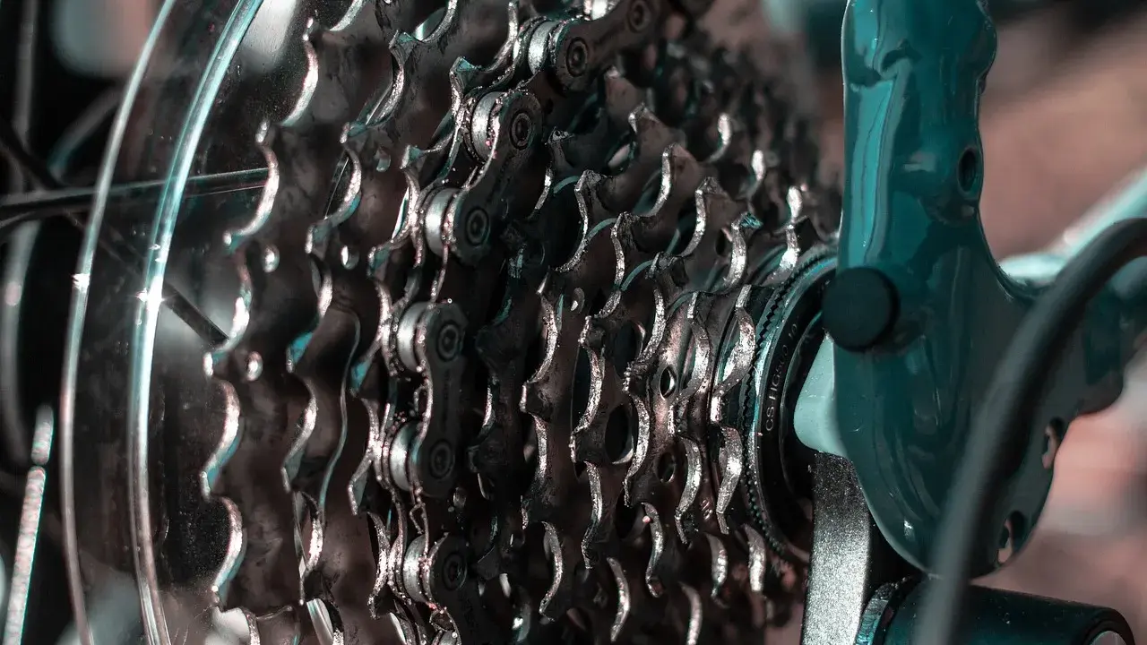 Zbliżenie na kasetę zębatek rowerowych i mocowanie przerzutki tylnej. Metalowe zębatki i łańcuch tworzą skomplikowany mechanizm.