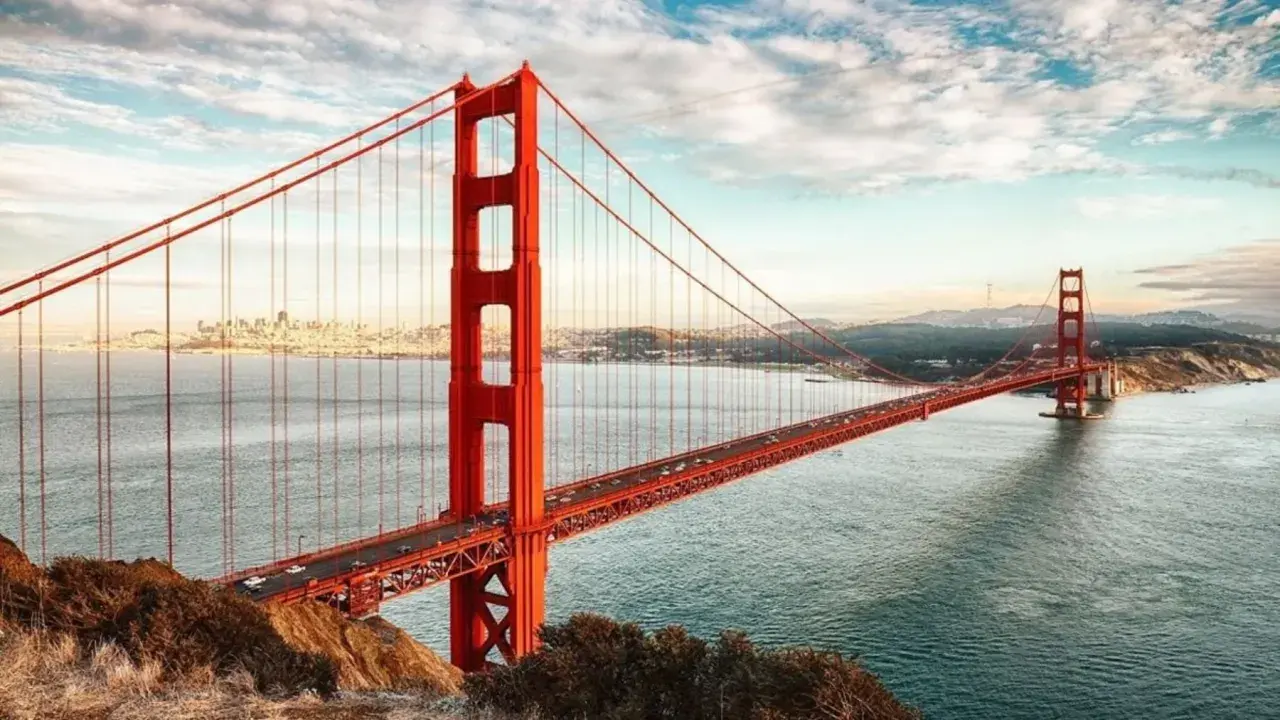 El icónico puente Golden Gate, con su distintivo color naranja, se extiende sobre el agua. ¿Cuánto mide el puente de San Francisco? Es una maravilla de la ingeniería.