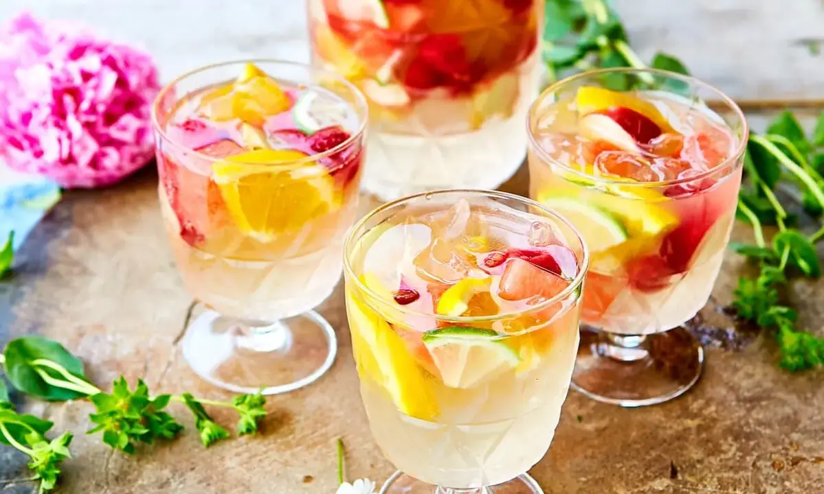Färgglad vit sangria med frukt som apelsin, lime och hallon. Perfekt för en sommardag, här är ett enkelt recept.