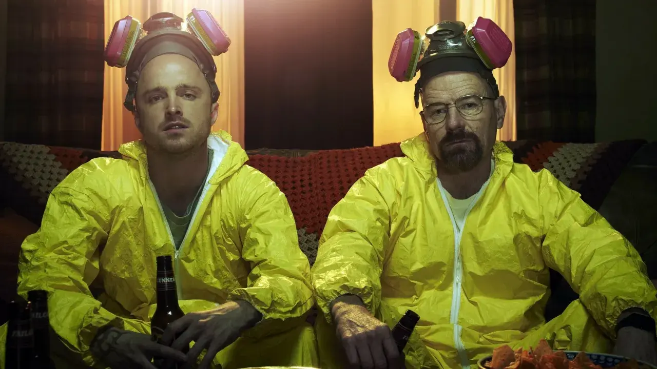 Bryan Cranston och Aaron Paul i gula skyddsdräkter och gasmasker, en ikonisk scen från filmer och tv-program.