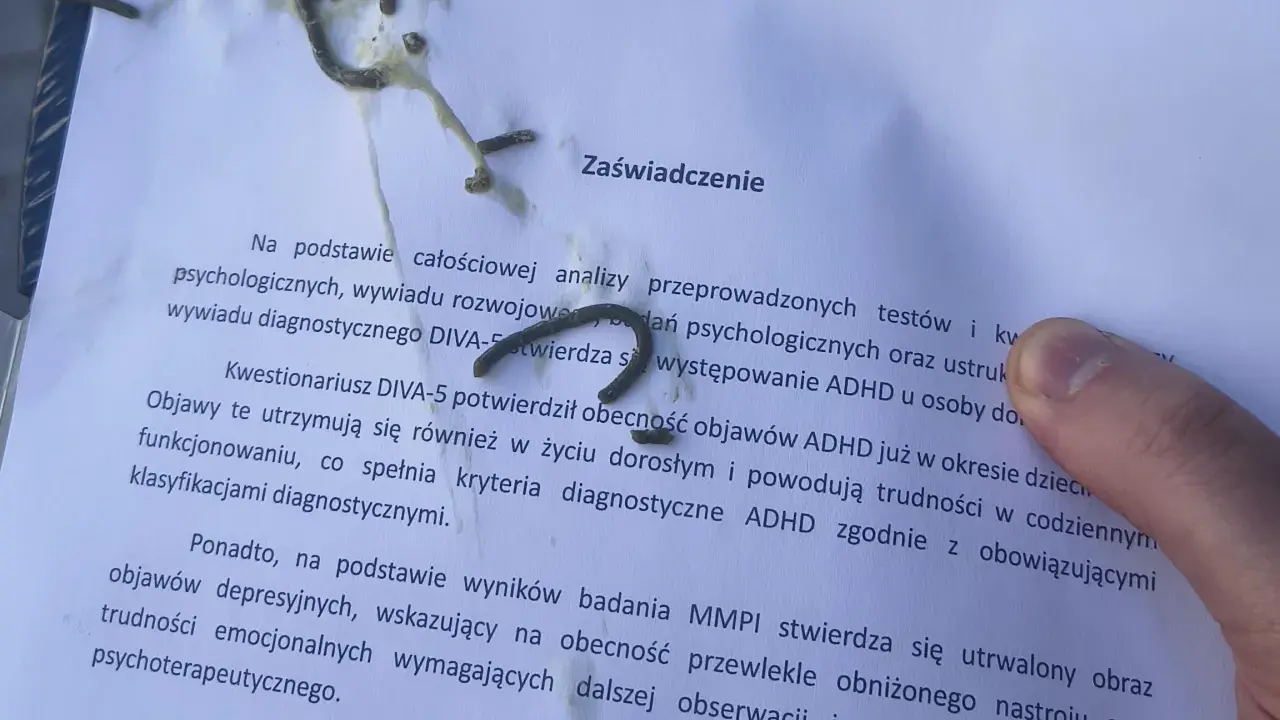 Na zaświadczeniu o ADHD, obok tekstu, widać ślady czegoś, co może przypominać trudności w pisaniu, jak przy dysgrafii.
