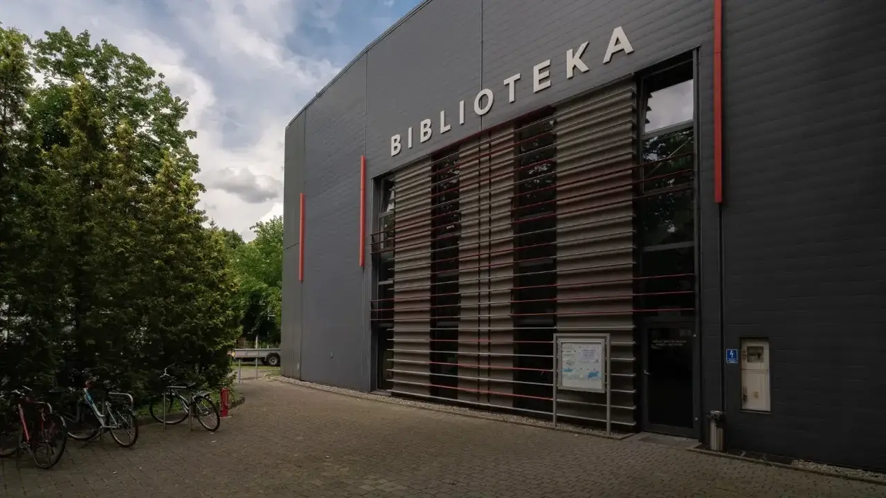 Nowoczesna biblioteka na terenie Akademii Ignatianum w Krakowie. Obok stoją rowery.