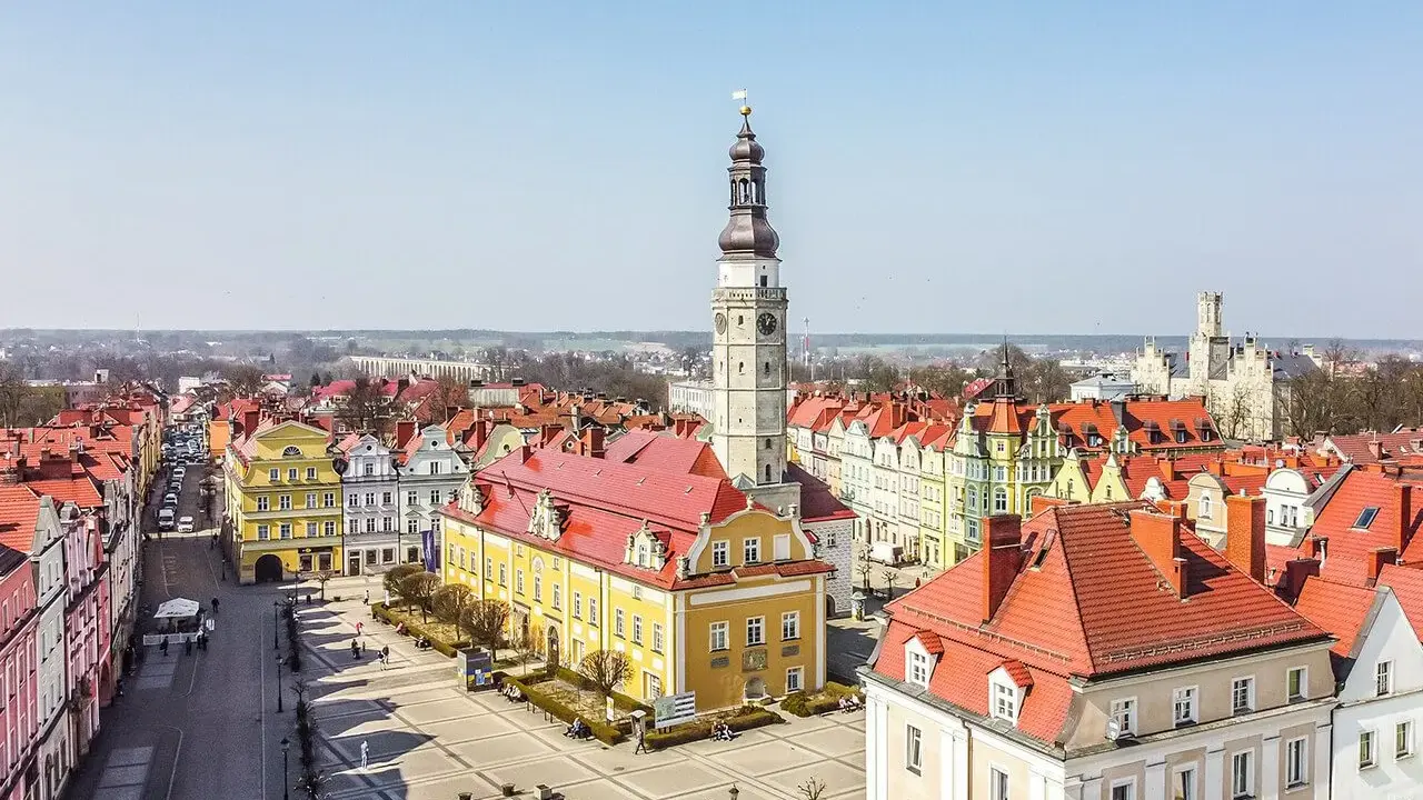 Rynek w Bolesławcu z ratuszem i wieżą zegarową. Kolorowe kamienice i brukowany plac tworzą urokliwe bolesławiec atrakcje.
