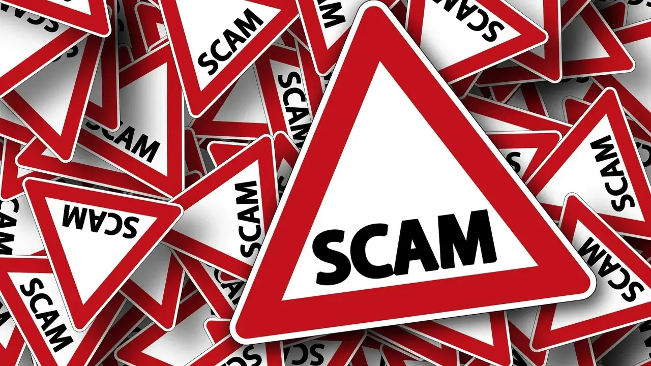 Viele rote Dreiecke mit der Aufschrift "SCAM" stapeln sich. Vorsicht vor der aktuellen Online-Betrugsmasche!
