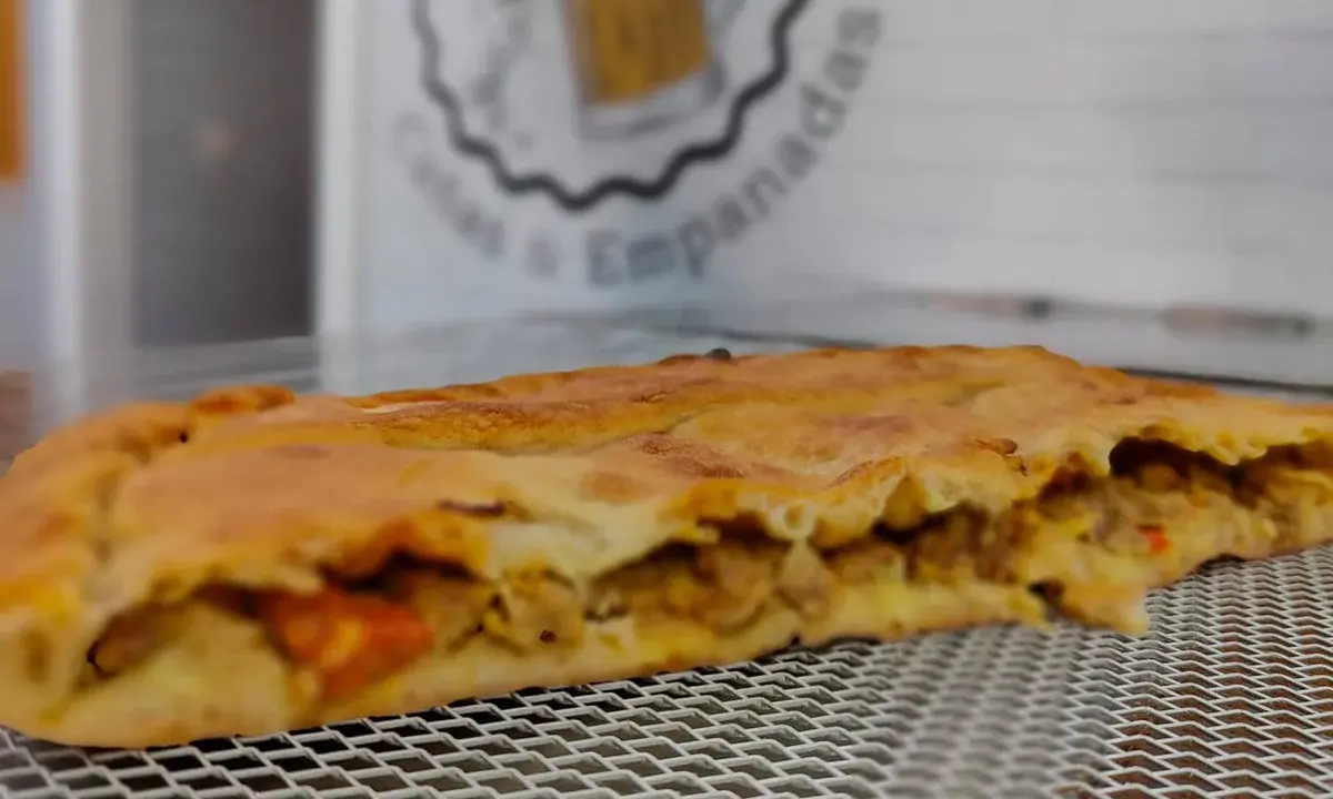 Empanada dorada rellena de carne y verduras. Perfecta para acompañar con una ensalada fresca o una salsa picante.