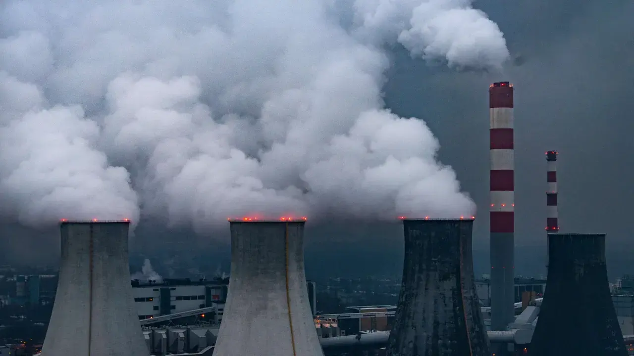Rauchschwaden steigen aus Kühltürmen und Schornsteinen von Kohlekraftwerken in Polen auf, ein düsteres Bild der Energieerzeugung.