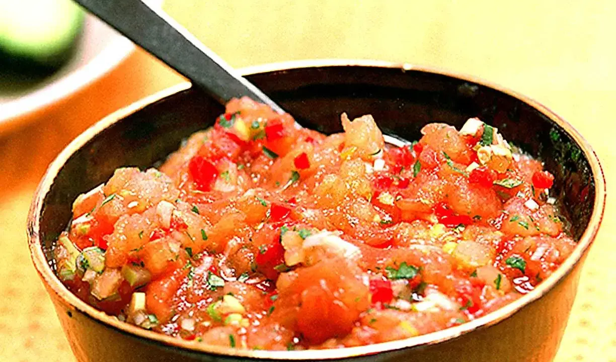 En skål med färsk pico de gallo, en klassisk mexikansk salsa med hackade tomater, lök och koriander. Perfekt till tacos!