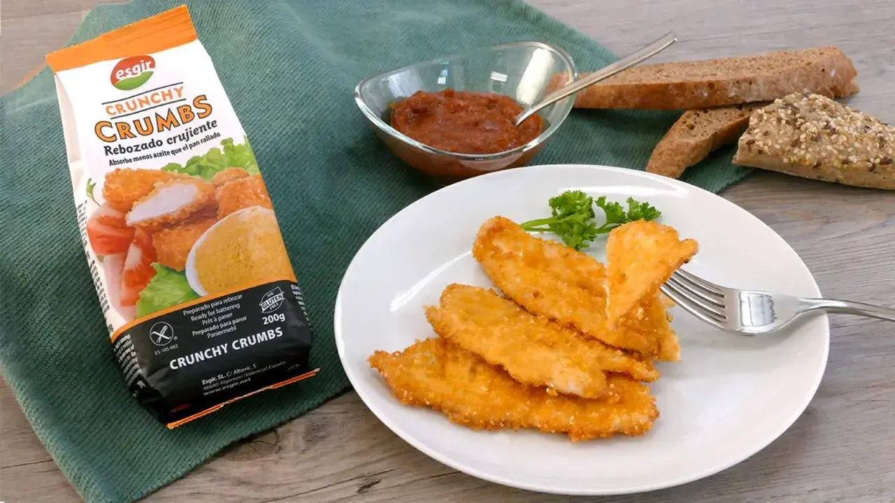 Escalope de pollo crujiente, listo para disfrutar. Acompañado de pan y salsa.