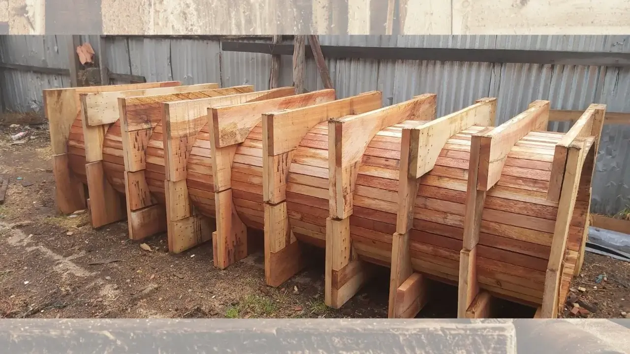 Encofrados de madera apilados, listos para dar forma a grandes estructuras circulares.