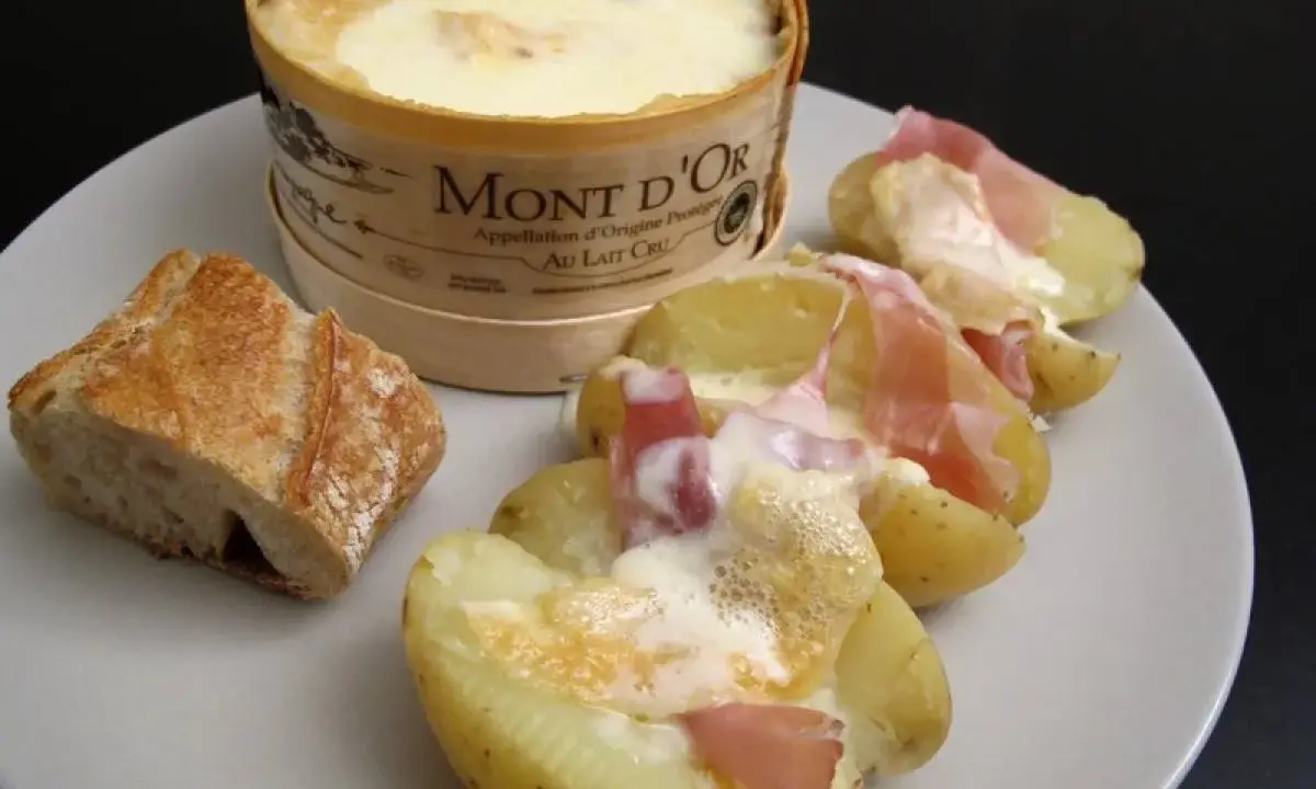 Un Mont d'Or fondant, pommes de terre et jambon cru : un plat réconfortant, typique des spécialités du Jura.
