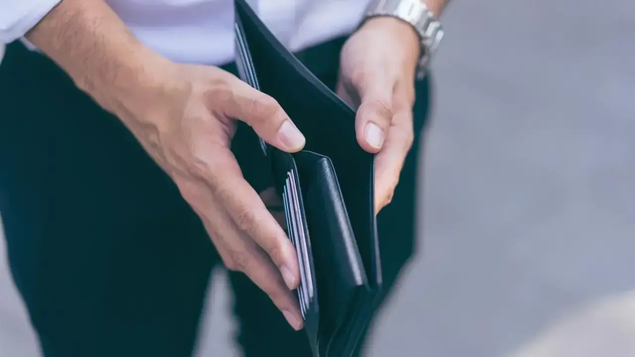 Puste ręce trzymające portfel, symbolizujące trudności finansowe i przykłady stagflacji.
