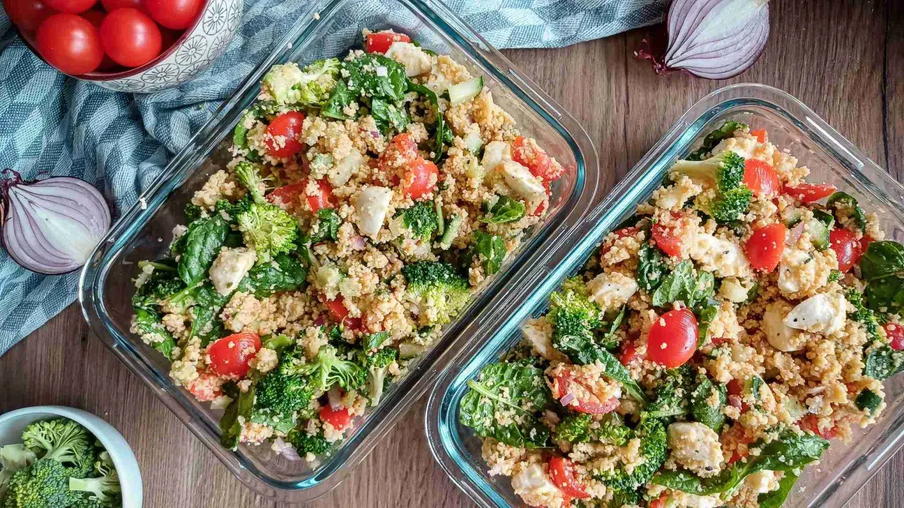 Zwei Behälter mit Couscous-Salat, reich an Couscous-Protein, gefüllt mit Brokkoli, Tomaten, Spinat und Mozzarella.