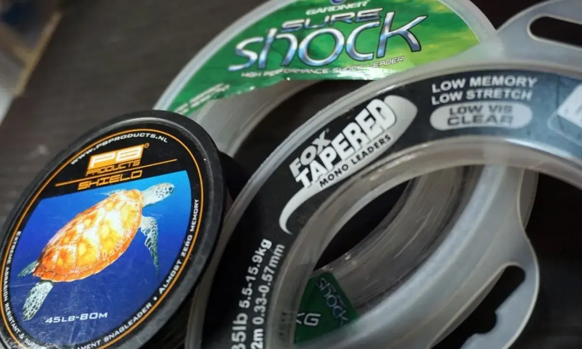 Wybór między żyłką a plecionką to kluczowa decyzja wędkarza. Na zdjęciu widać różne rodzaje żyłek, w tym PB Products Shield i Fox Tapered Mono Leaders.