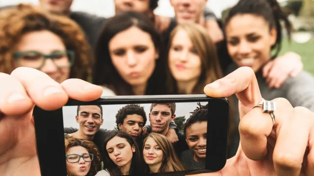 Grupa przyjaciół robi selfie. To pokolenie z od kiedy? Zawsze razem, uśmiechnięci i gotowi na nowe przygody.