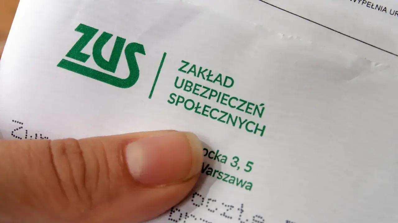Palec wskazujący na dokumencie ZUS. Pytanie: ile trzeba być na zwolnieniu aby dostać odszkodowanie z ZUS?