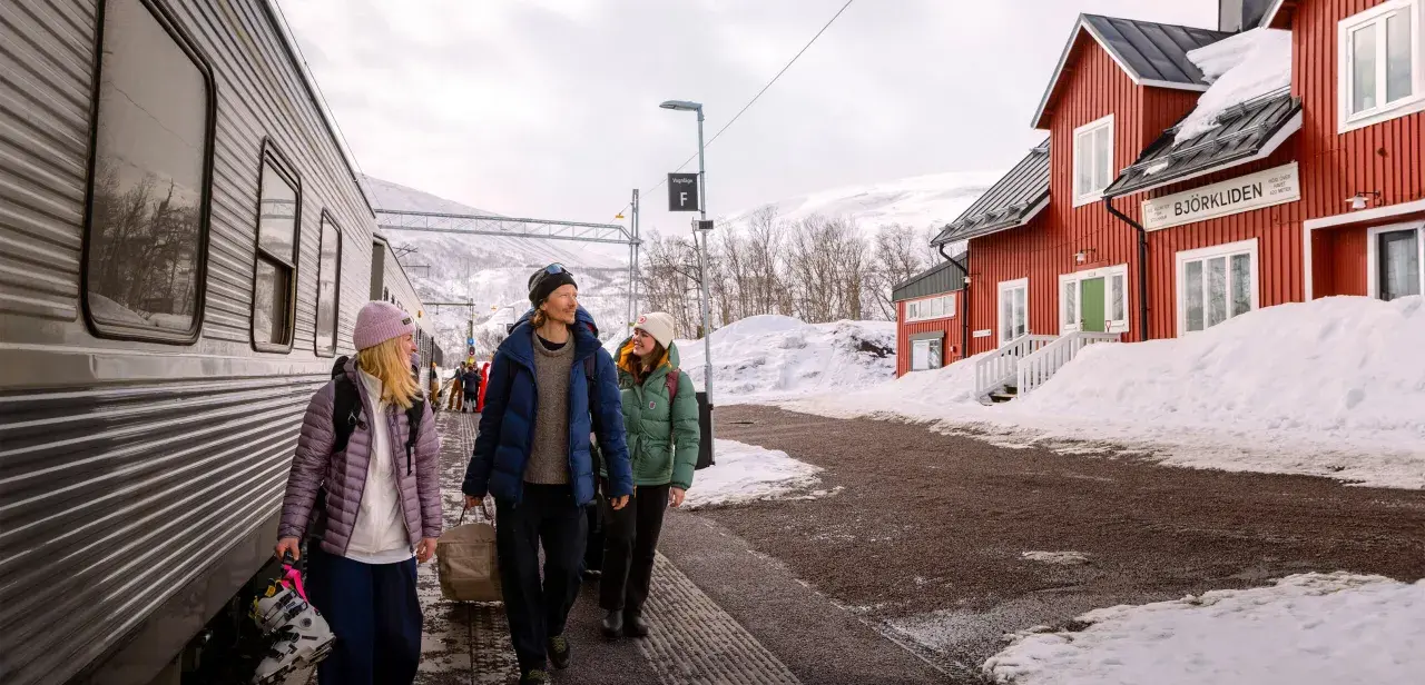 Tre vänner anländer till Björkliden med tåg, redo för vinteräventyr. En röd stationsbyggnad och snöklädda berg vittnar om att de är framme vid en av Sveriges mest natursköna platser, inte långt från evens flygplats.