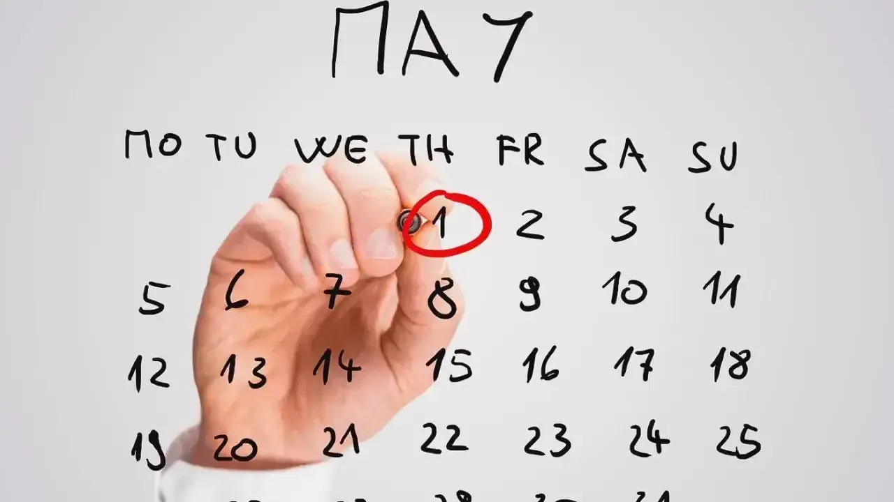 Ręka zakreśla czerwonym pisakiem datę 1 maja na kalendarzu. To ważne awizo, początek miesiąca.