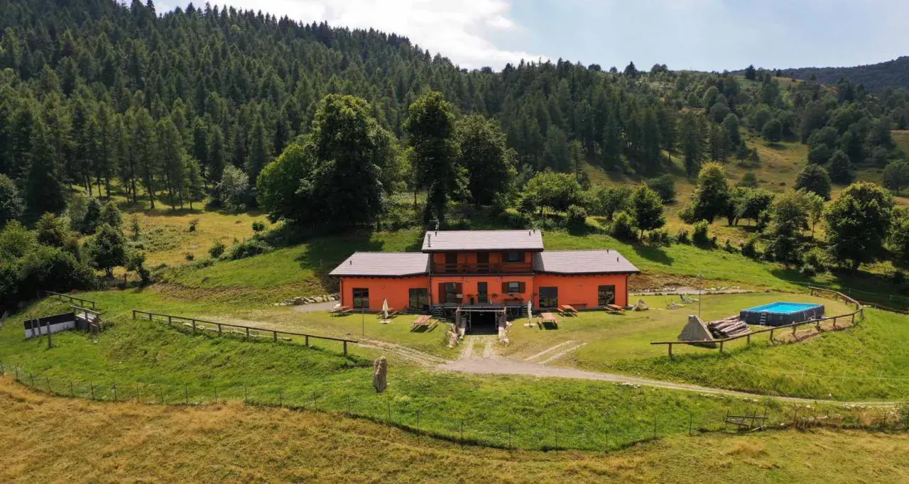 Un weekend in Lombardia tra natura e relax: casa arancione con piscina immersa nel verde, ideale per scoprire cosa fare nel weekend in Lombardia.