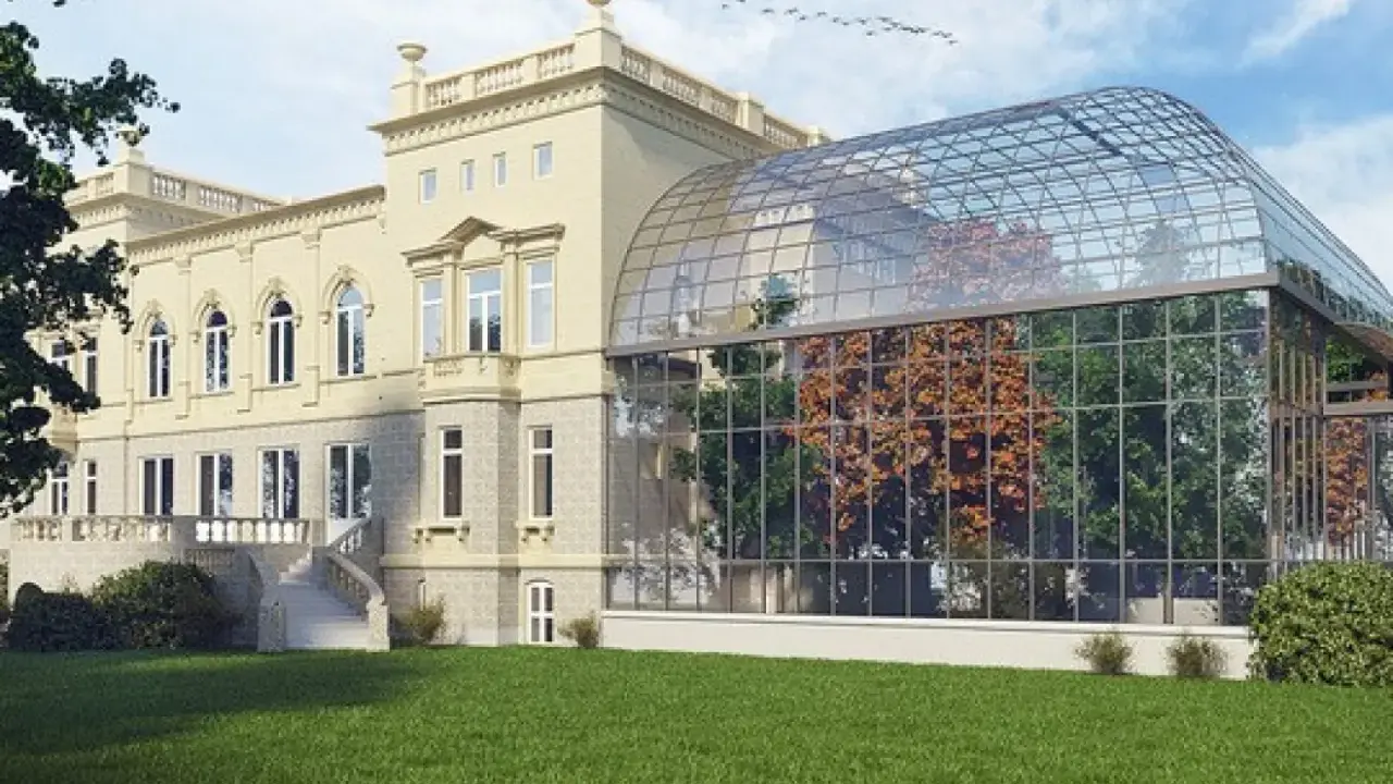 Elegancka willa z oranżerią, prawdopodobnie najdroższy hotel w Łodzi, otoczona zielonym trawnikiem.