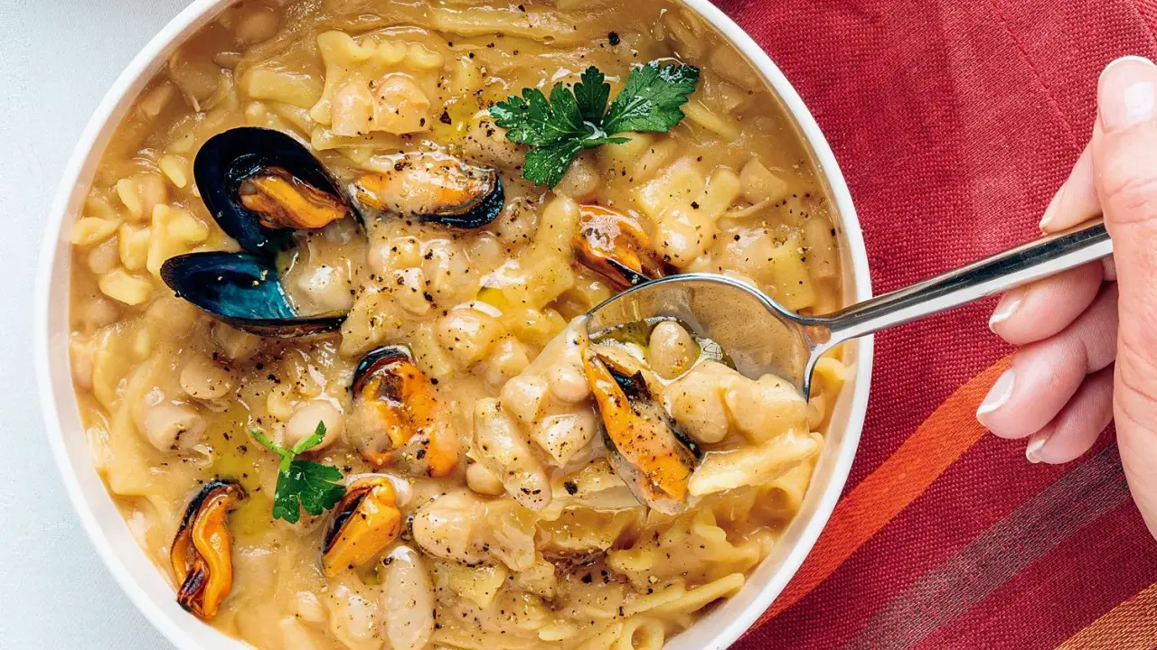 Un plato humeante de pasta fagioli e cozze, con mejillones jugosos y alubias cremosas en un caldo sabroso.