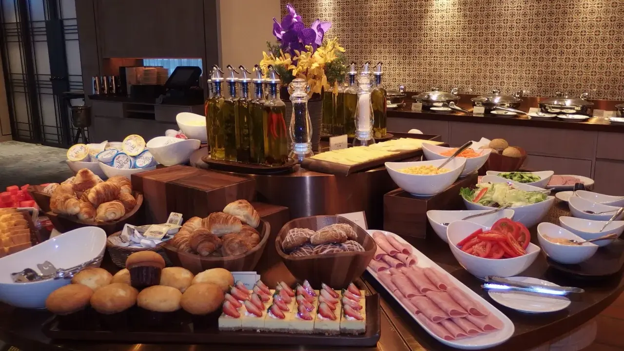 Ideas para buffet desayuno hotel: croissants, pasteles de fresa, jamón, ensaladas, frutas y panes.
