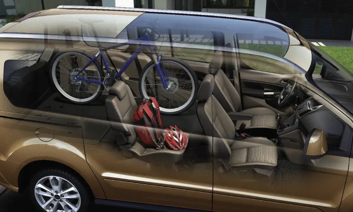 Interior de furgoneta con bicicleta azul y cascos rojos. ¡Cuidado con la multa por llevar bici dentro del coche!