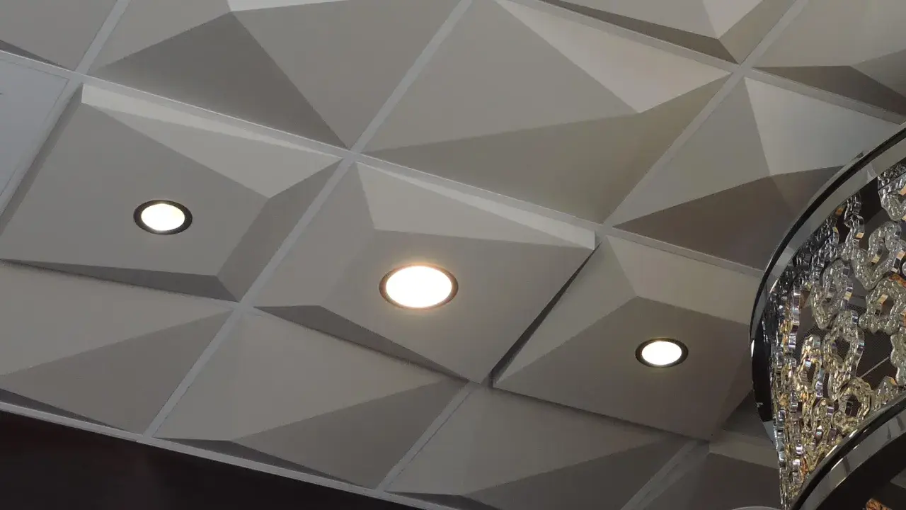 Nowoczesny sufit z geometrycznymi panelami i wbudowanymi punktami świetlnymi. Świetna alternatywa dla kasetonów, nadająca wnętrzu charakteru.