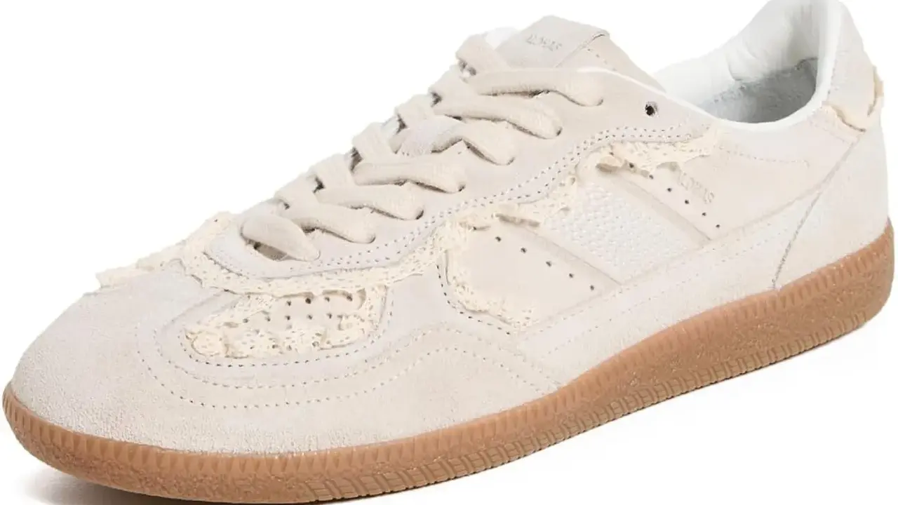Zapatilla deportiva de ante color crema con detalles de encaje a crochet y suela de goma.
