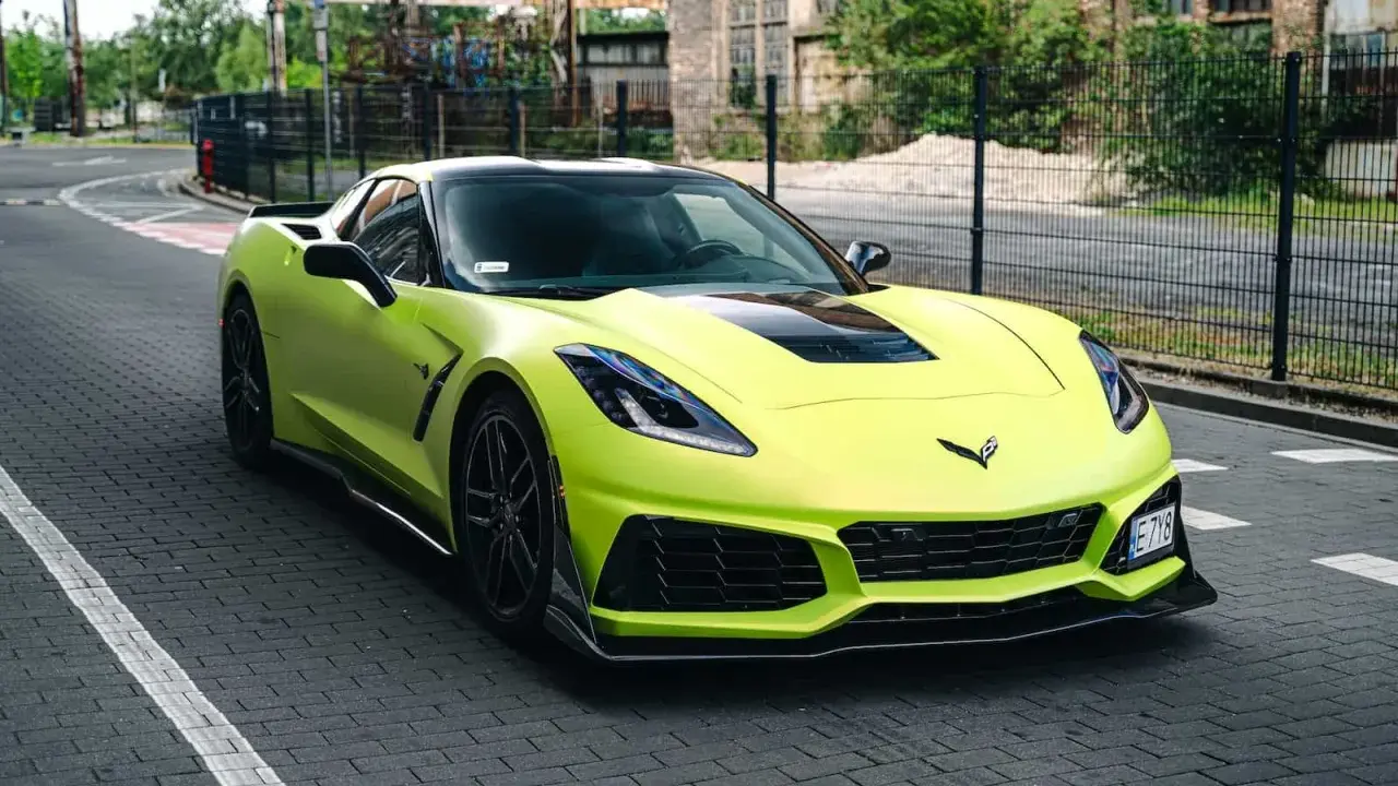 Jasnozielony Chevrolet Corvette C7 na brukowanej drodze. Zastanawiasz się nad corvette c7 cena?