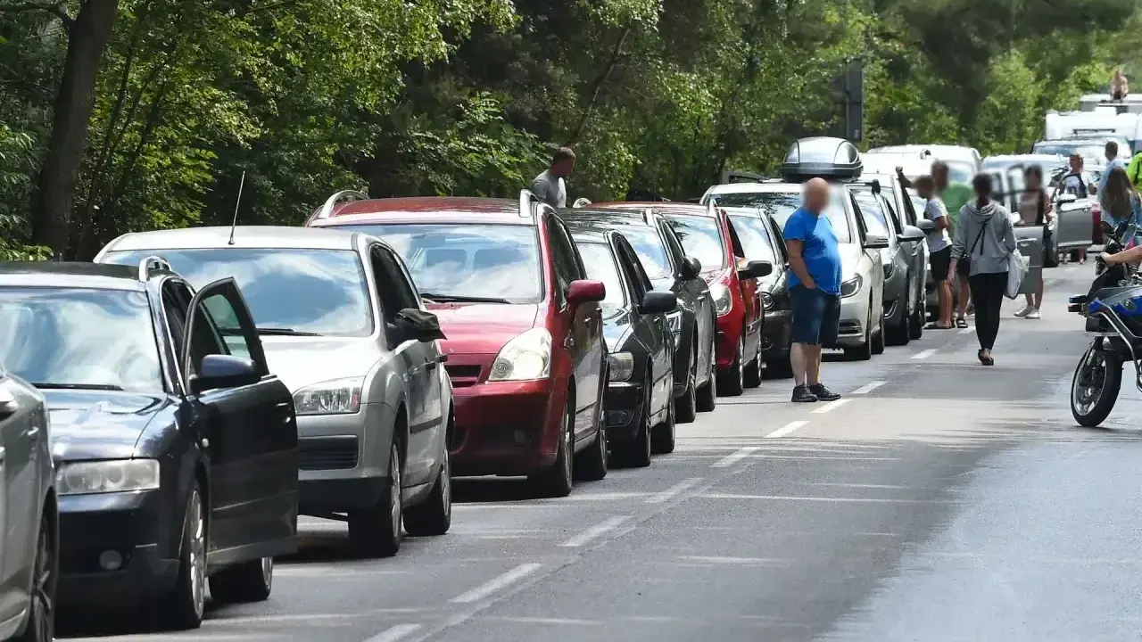 Długi korek samochodów na trasie do Helu. Kierowcy stoją w upale, czekając na przejazd.