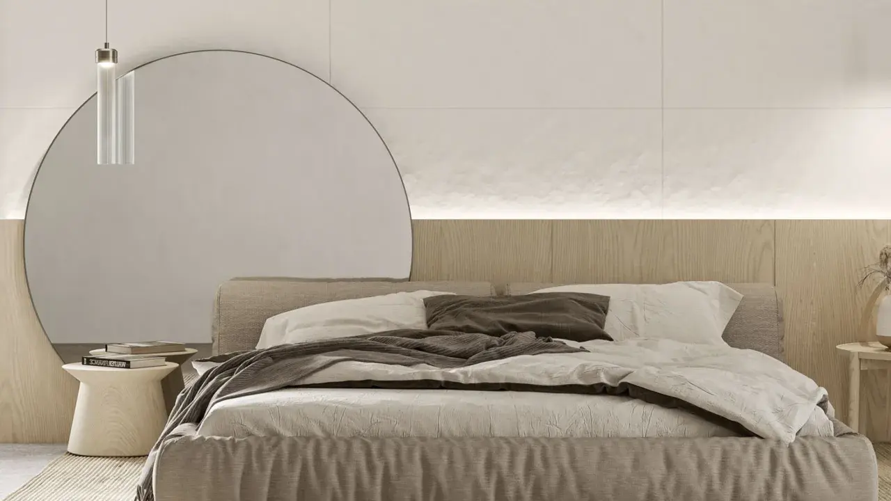 Przytulna sypialnia inspiracje: minimalistyczne łóżko z lnianą pościelą, duża okrągła lustrzana ściana i drewniane akcenty tworzą spokojną atmosferę.