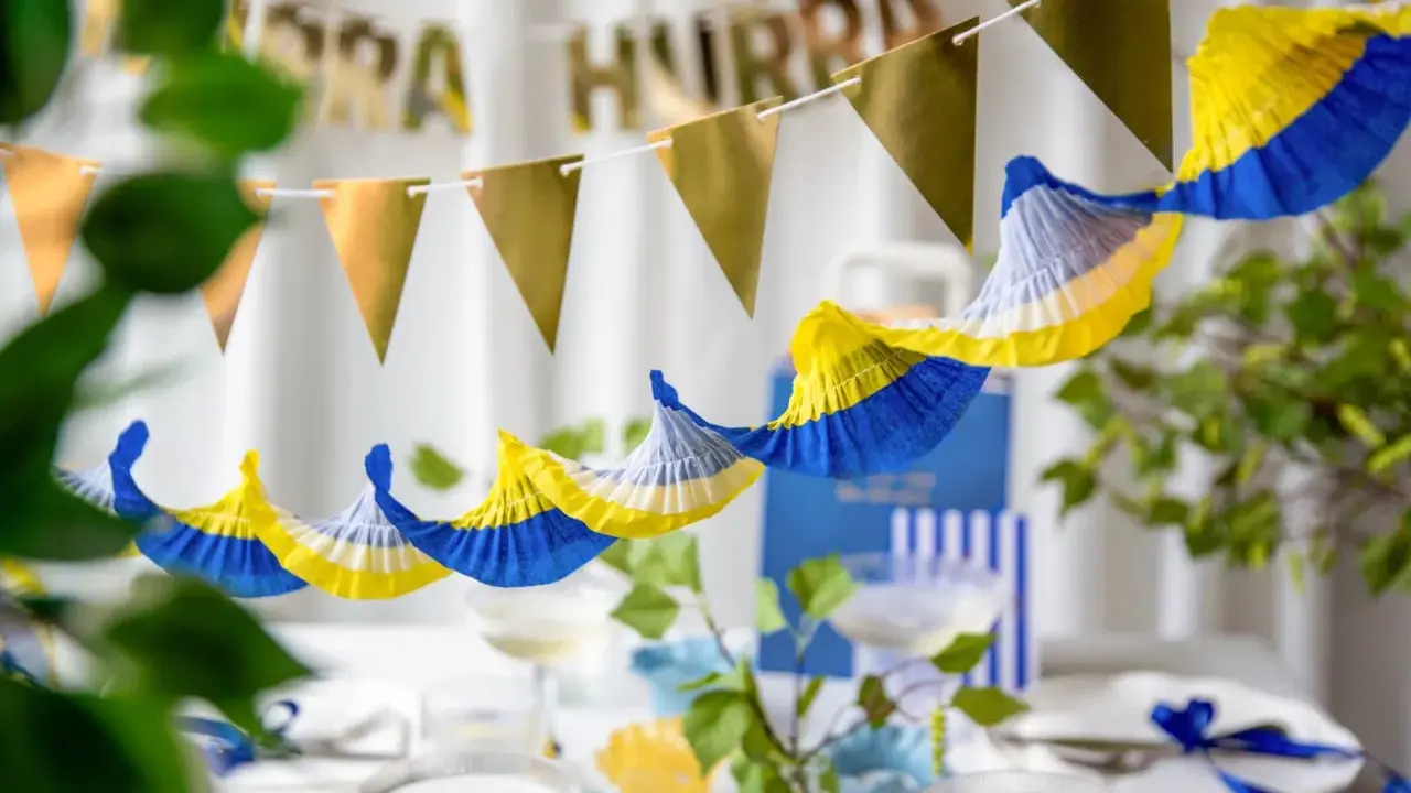 Festlig student dekoration inspiration med girlanger i guld och blått/gult. Perfekt för att fira!