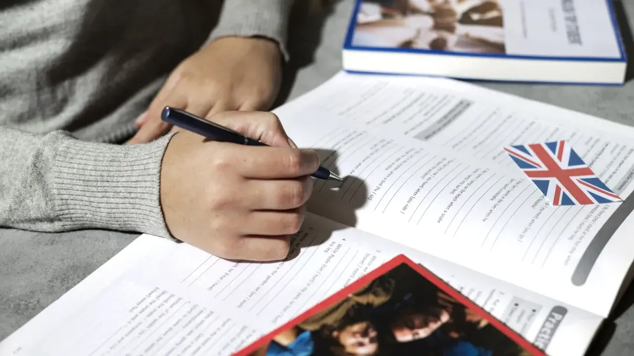 Osoba pisze ćwiczenia z angielskiego, przygotowując się do egzaminu certyfikat C2 angielski.